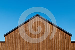 Facade decoration of the roof gable with natural wood plank of a new modern house, copy space