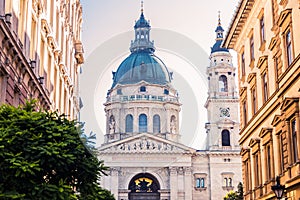 The facade and dome of the Basilica of St. Stephen in Budapest, between two buildings.