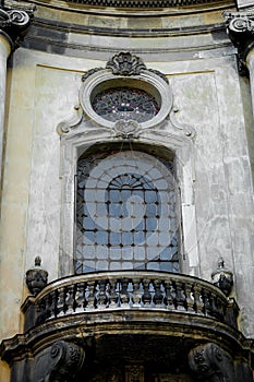 Facade of the Dominican Cathedral, Lviv, Ukraine. Fragment window with metal gril and balcony. Close up.