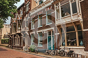 Facade of elegant brick buildings and bicycles on the street in a cloudy day at Dordrecht.