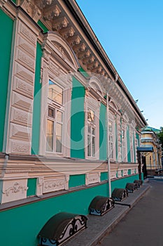 Facade of a green house with windows in white frames