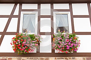 Facade of half-timbered house with geranium flowers