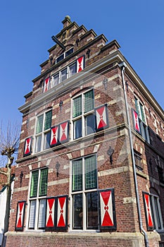 Facade of a historic building with red and white shutters in Meppel