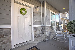 Facade of a home with a simple wreath hanging on the white wooden door