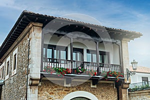 Facade of a house with a balcony decorated with potted flowers