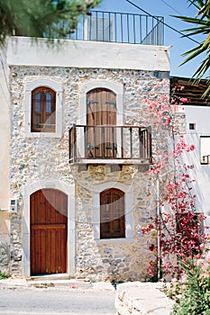 Facade of house in Greek style. Entrance to house in one of villages of Crete. Traditional style.