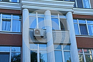 Texture of many windows on a gray brown concrete wall with white columns