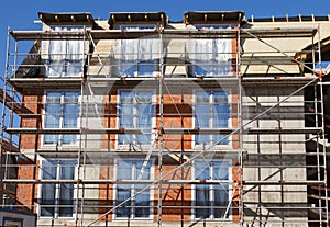 The facade of a house under construction with scaffolding