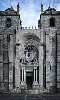 Facade of the imposing and somber Porto Cathedral, contrasting with blue sky. The famous Se do Porto in Portugal.