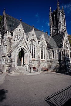 Facade of Kylemores Neo Gothic Church against a blue sky