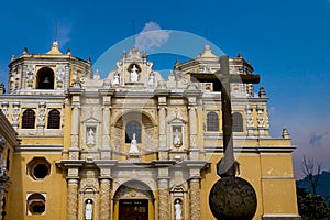 The facade of the `La Merced` church with stone cross in Antigua, Guatemala