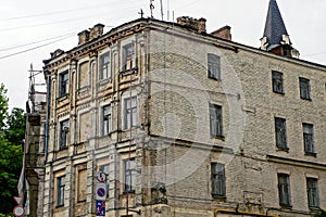 Facade of a large brown old brick house with a row of windows