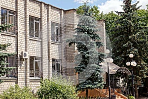 The facade of a large gray brick house with a row of windows on the wall