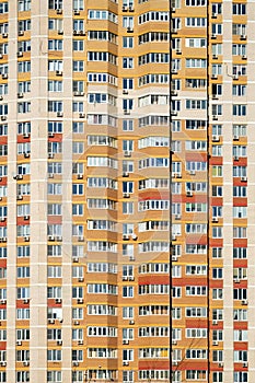 Facade of a large multi-storey block of flats with many windows front view closeup