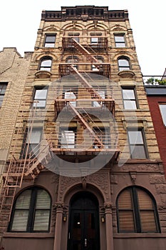 Facade of the late 19th-century multistory apartment building with old retail store in the ground floor, in the South Village, NYC