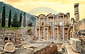Facade of Library of Celsus in Ephesus under yellow sky