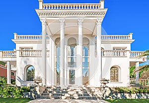 The facade of a luxurious residence with columns in the Corinthian style, with large windows. Luxury house in a classic style. Be