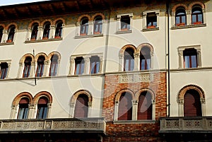 Facade with many windows and two elegant balconies of a historic palace in Treviso in the Veneto (Italy)