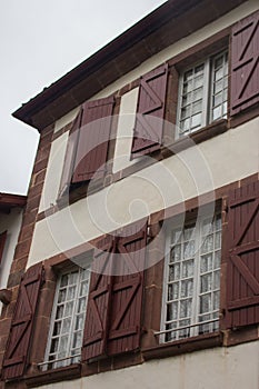 Facade of medieval building. Exterior of ancient house with wooden window shutters. Vintage architecture. Village of middle age.
