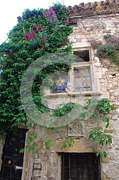 Facade of a medieval house with two stained glass windows