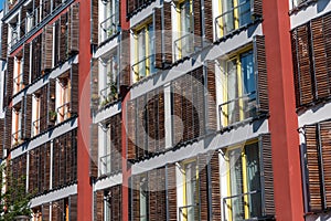 Facade of a modern apartment house with wooden windows shutters