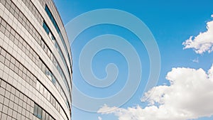 Facade of a modern building at an angle against a bright sky. Background image