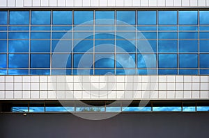 Facade of modern building. Reflection of sky with clouds in windows