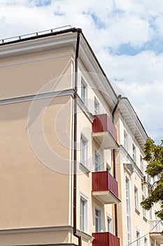 The facade of a modern building in which people live in apartments in the city center. blue sky background