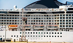 The facade of a modern cruise ship with lifeboats