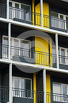 The facade of a modern multi-storey building, windows and balconies, yellow and black walls, the concept of urbanism and city