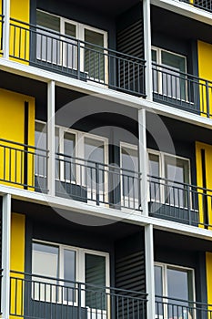 The facade of a modern multi-storey building, windows and balconies, yellow and black walls, the concept of urbanism and city