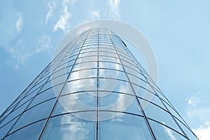 Facade of modern skyscraper with reflection of cloudy sky, low angle shot,copy space