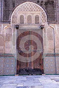 Facade of mosque with old style closed door and mosaic wall
