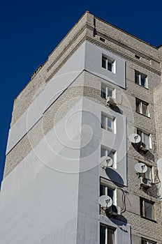 Facade of a multi-storey building with many satellite antennas photo