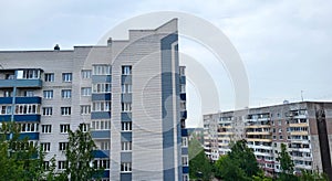 The facade of a multi-storey building with a sharp angle and blue balconies