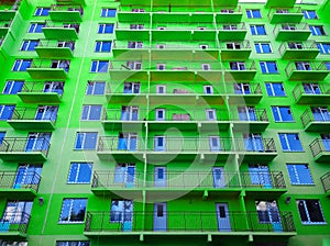 Facade of new green color residential building. Sale and rental of economy class apartments and comfortable housing. Cityscape.