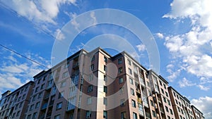 Facade of new multi-story residential building. Blue sky background. House Share. Real estate investing. Buy, sale, rental and ins