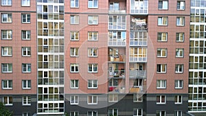 Facade of a new multi-story residential building. Sale and rental of economy class apartments and comfortable housing. Cityscape.