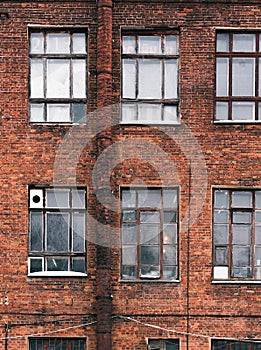 Facade of an old brick building in loft style. High Windows and textural materials