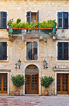 Facade of old building with balcony and windows with trees and f