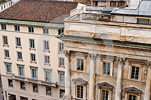 Facade of an old building with a colonnade and balusters on the balconies. Milan, Italy