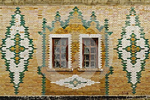 The facade of an old building is faced with glazed bricks. Steppe Zeikhgauz