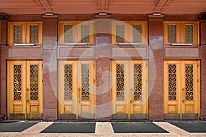 Facade of old building is lined with marble entrance wooden doors.