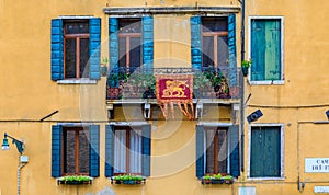 Facade of an old building with shutters and ornate windows in Venice Italy