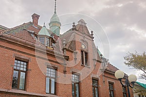 Facade of old building with spire and clock on roof in Zelenogradsk. German architecture of last century