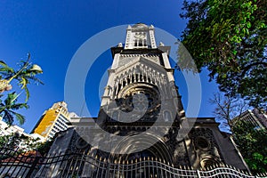 Facade of an old church next to buildings.