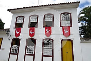 Facade of an old colonial townhouse adorned with divine flags