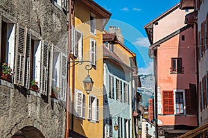 Facade of old and colorful buildings with windows in Annecy.