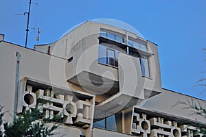 The facade of an old communist building, straight lines and gray concrete