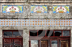 Facade of old, decayed house with beautiful tile pattern